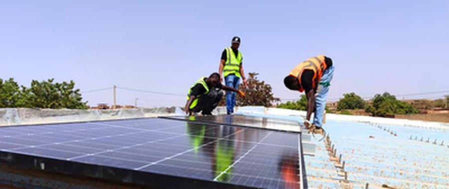 Techniciens Metavolt Énergie installant des panneaux solaires en toiture, centre de santé, Burkina Faso