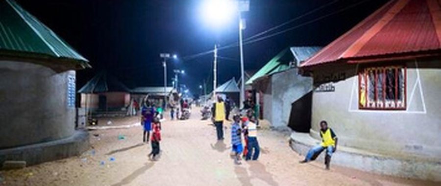 Rue de village éclairée la nuit par un lampadaire solaire autonome, Cameroun